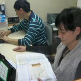 Volunteer assisting visually impaired braille production officer